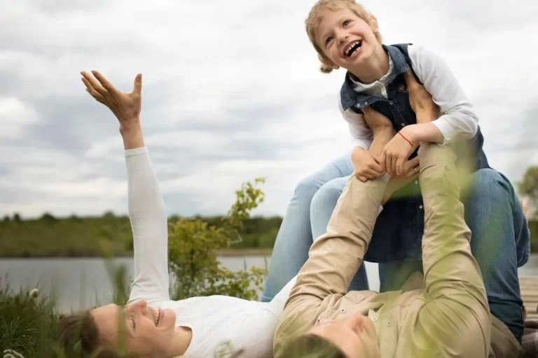 Çimlerde oynayan ve gülüşen anne ve çocuk ile prim iadeli hayat sigortası ile klasik hayat sigortası farkı yaşam güvencesi teması.